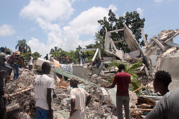 Menschen suchen in den Trümmern eines Hotels auf Haiti nach Überlebenden.