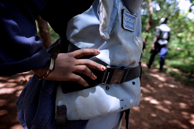 senegal-entminung-frauen Zu sehen ist eine Nahaufnahme einer Frau in Schutzkleidung. Mit Händen in den Hüften impliziert sie Stärke und Bereitschaft